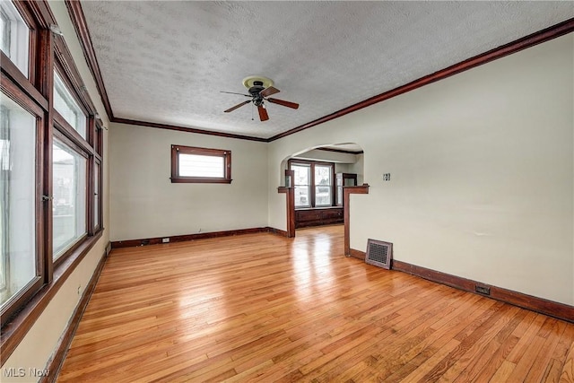 spare room with a textured ceiling, ceiling fan, crown molding, and light hardwood / wood-style flooring