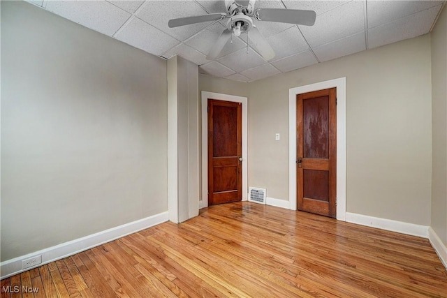 unfurnished room featuring a paneled ceiling, ceiling fan, and light hardwood / wood-style flooring