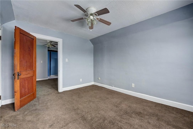 unfurnished room featuring lofted ceiling, a textured ceiling, ceiling fan, and dark carpet