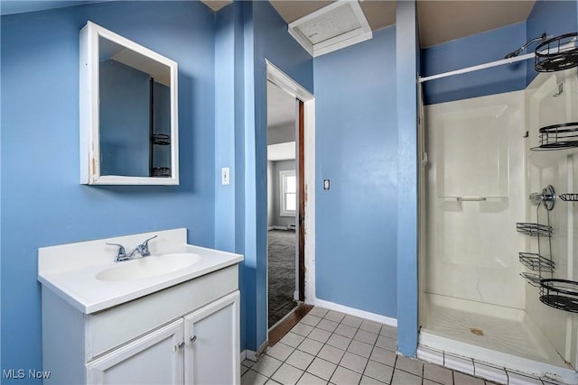 bathroom with tile patterned flooring, walk in shower, and vanity