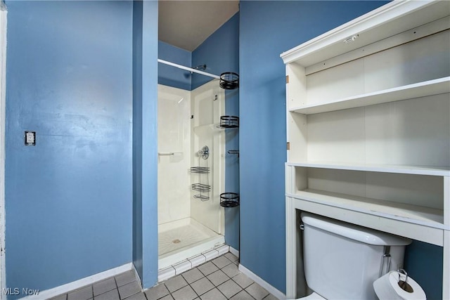 bathroom featuring toilet, a shower, and tile patterned floors