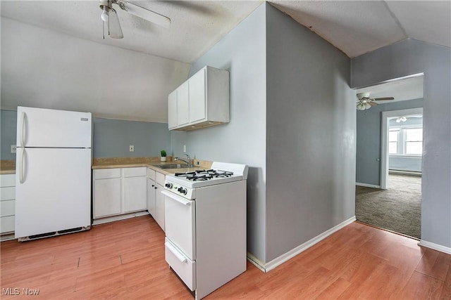 kitchen featuring white appliances, baseboard heating, sink, white cabinetry, and lofted ceiling