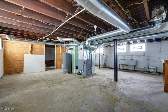 basement with sink, water heater, and heating unit