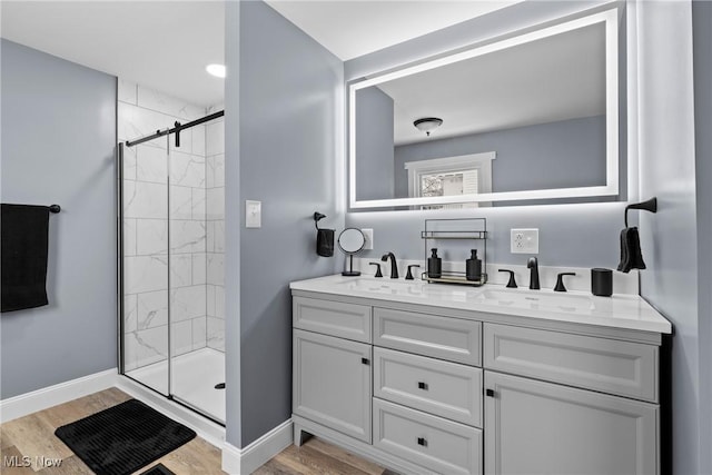 bathroom with vanity, a shower with shower door, and wood-type flooring