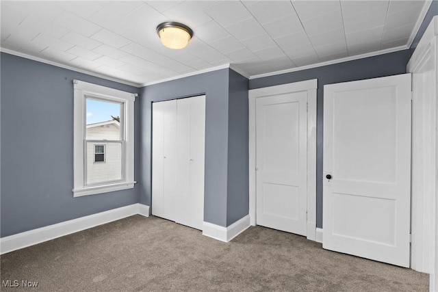 unfurnished bedroom featuring carpet floors, ornamental molding, and multiple closets