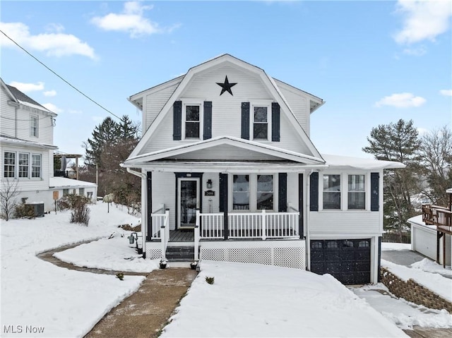 view of front of property featuring a garage, covered porch, and cooling unit