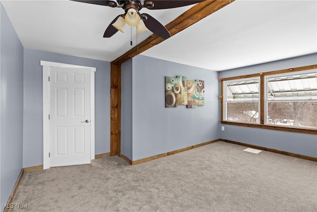 unfurnished bedroom with ceiling fan, light carpet, and beamed ceiling