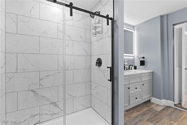 bathroom featuring a shower with door, hardwood / wood-style floors, and vanity