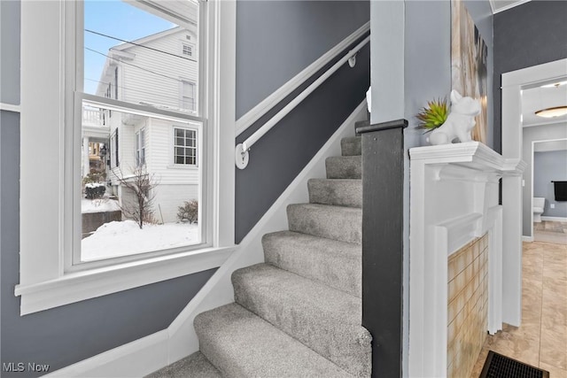 staircase featuring tile patterned flooring and plenty of natural light