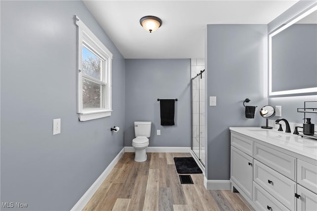 bathroom with a shower with door, toilet, vanity, and hardwood / wood-style flooring