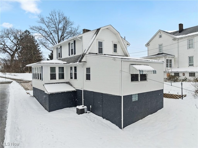 view of snow covered back of property