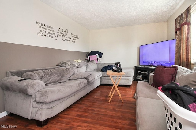 living room featuring a textured ceiling and dark hardwood / wood-style floors