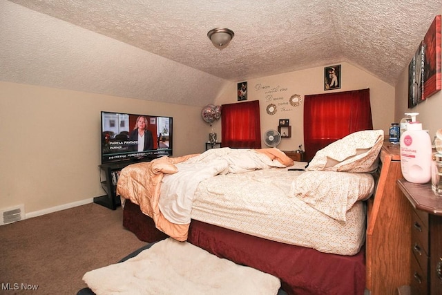 bedroom with lofted ceiling, a textured ceiling, and carpet