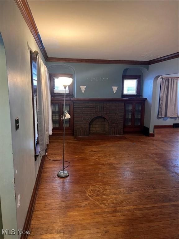 interior space with crown molding, a fireplace, and hardwood / wood-style flooring