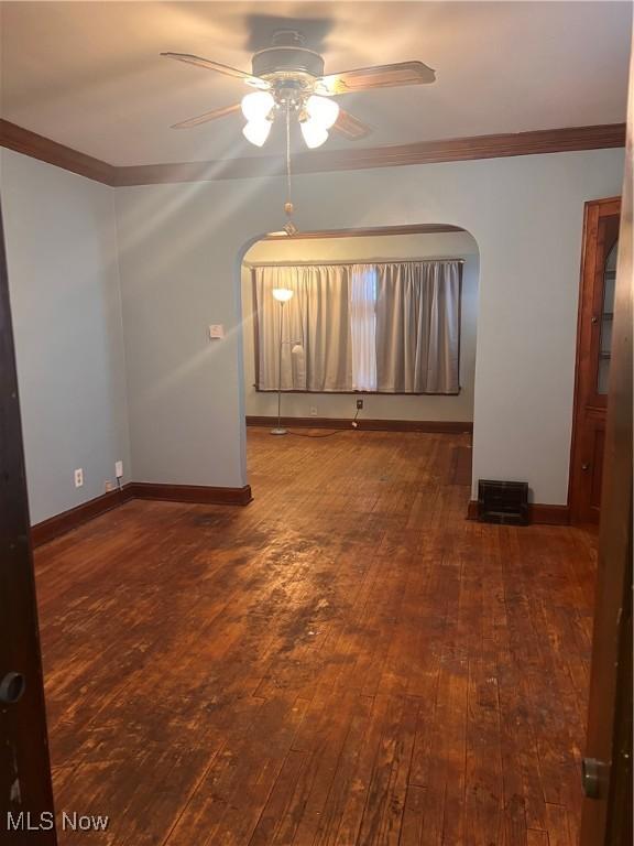 empty room featuring ceiling fan, dark hardwood / wood-style flooring, and ornamental molding