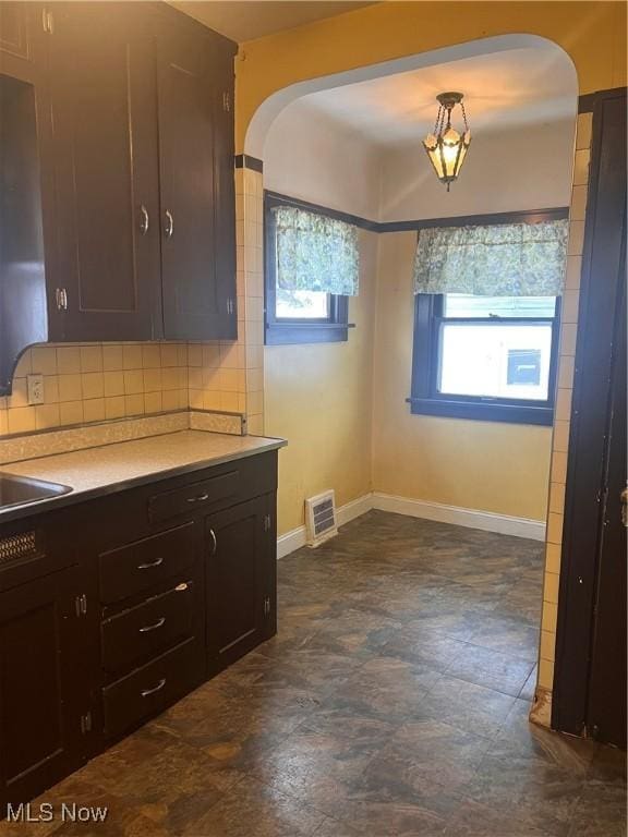 kitchen with decorative light fixtures, tasteful backsplash, and dark brown cabinetry