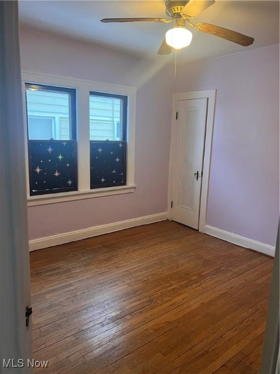 empty room featuring ceiling fan and dark hardwood / wood-style floors