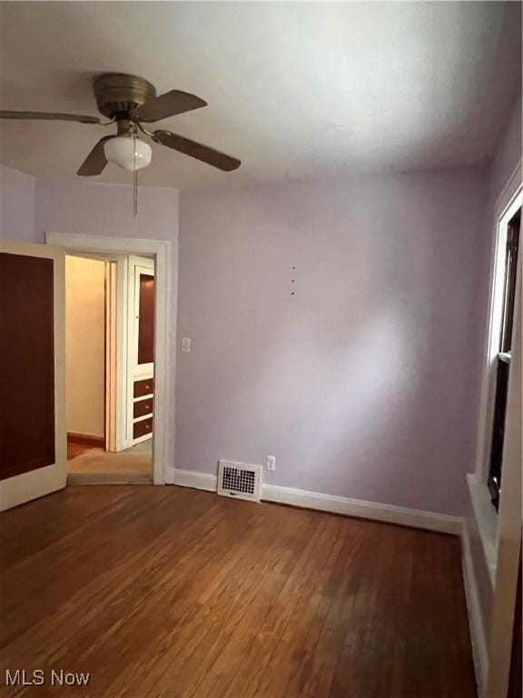 spare room with ceiling fan and dark wood-type flooring