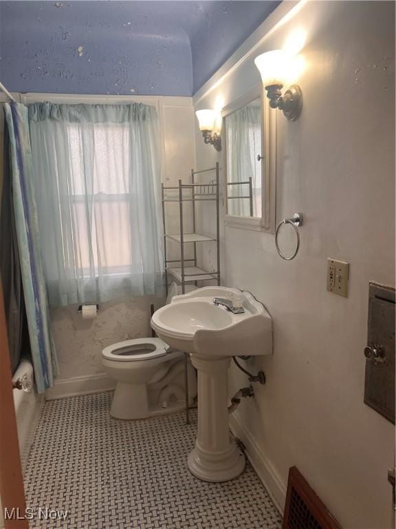 bathroom with toilet, tile patterned floors, and shower / bath combo