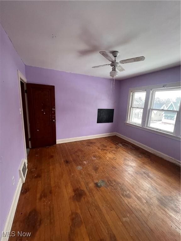 unfurnished room with dark hardwood / wood-style flooring and ceiling fan