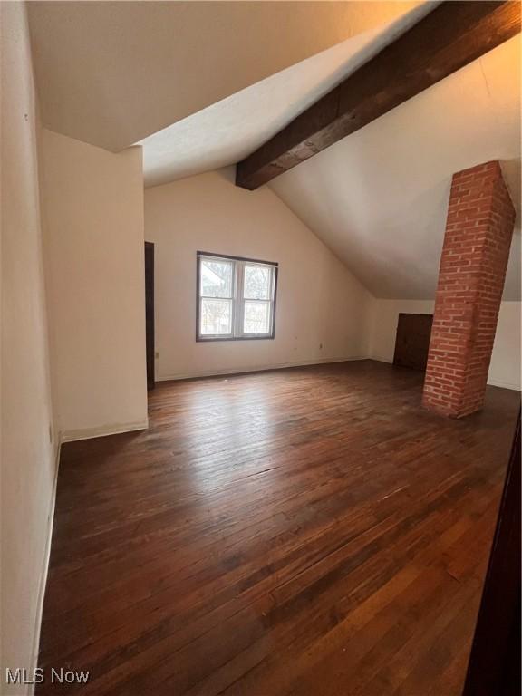 additional living space with vaulted ceiling with beams and dark hardwood / wood-style floors