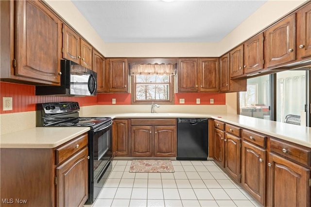 kitchen with black appliances, kitchen peninsula, light tile patterned flooring, and sink