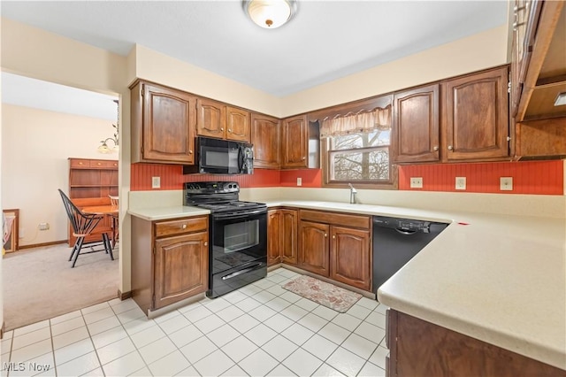 kitchen featuring black appliances, light carpet, and sink