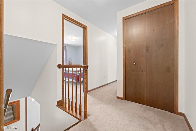 corridor featuring light colored carpet and vaulted ceiling