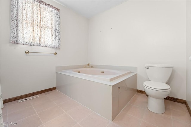 bathroom with toilet, tile patterned floors, and a tub to relax in