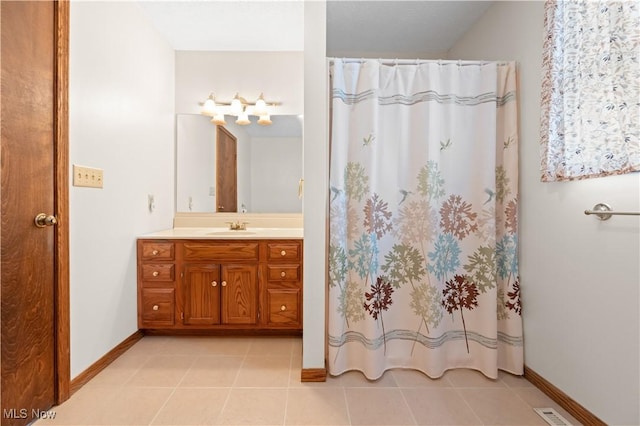 bathroom with tile patterned flooring, vanity, and curtained shower