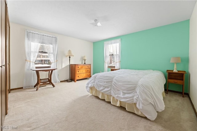 bedroom with light colored carpet, a closet, and multiple windows