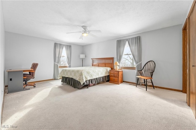 bedroom with light carpet, ceiling fan, and a textured ceiling