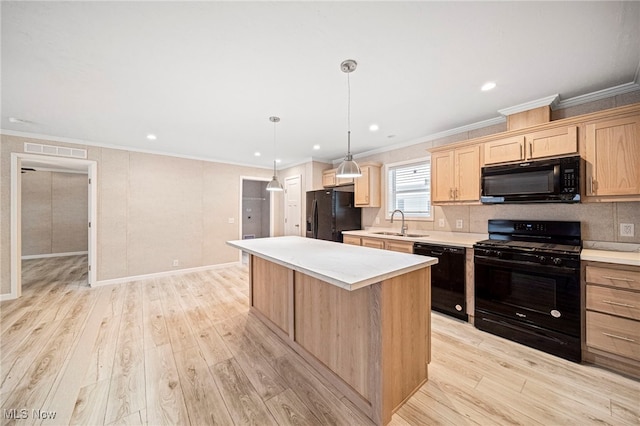 kitchen with pendant lighting, sink, a center island, black appliances, and light wood-type flooring