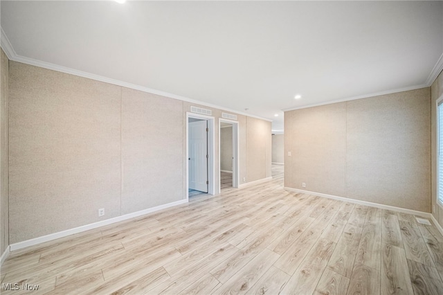 empty room with ornamental molding and light wood-type flooring