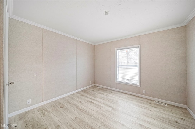 spare room with crown molding and light hardwood / wood-style floors