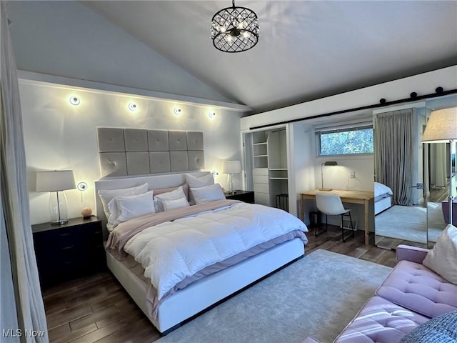 bedroom featuring lofted ceiling, a chandelier, a barn door, and dark hardwood / wood-style floors