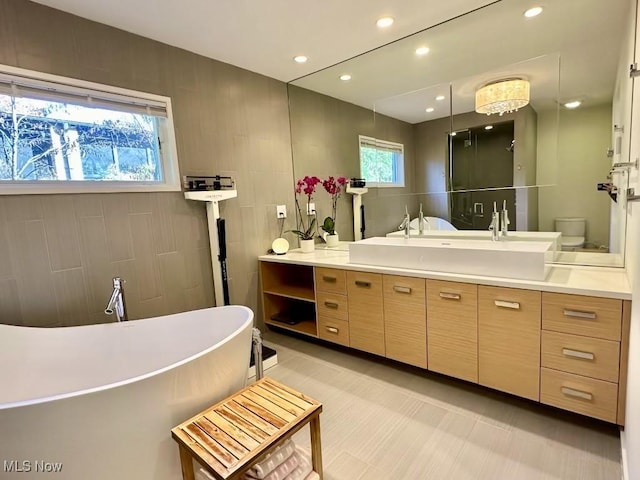 bathroom featuring toilet, a healthy amount of sunlight, a bathtub, and tile walls