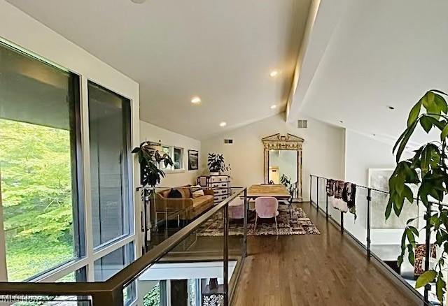 interior space featuring a healthy amount of sunlight, vaulted ceiling with beams, and hardwood / wood-style flooring