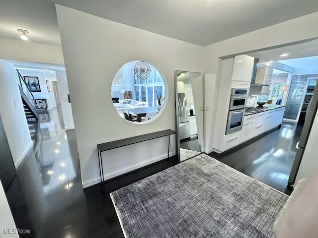 kitchen featuring stainless steel appliances, dark hardwood / wood-style flooring, and white cabinetry