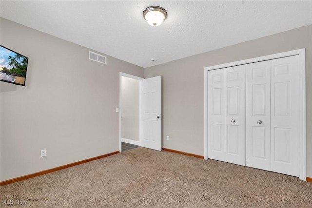 unfurnished bedroom featuring dark colored carpet and a closet