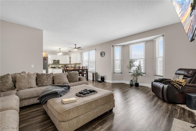 living room with dark hardwood / wood-style flooring, ceiling fan, and a wealth of natural light