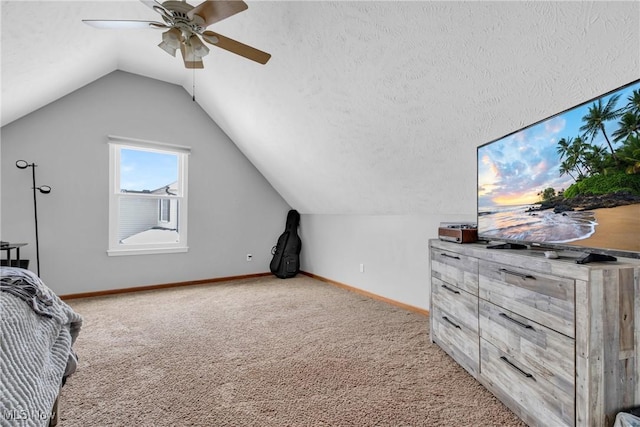 bedroom featuring vaulted ceiling, light colored carpet, ceiling fan, and a textured ceiling