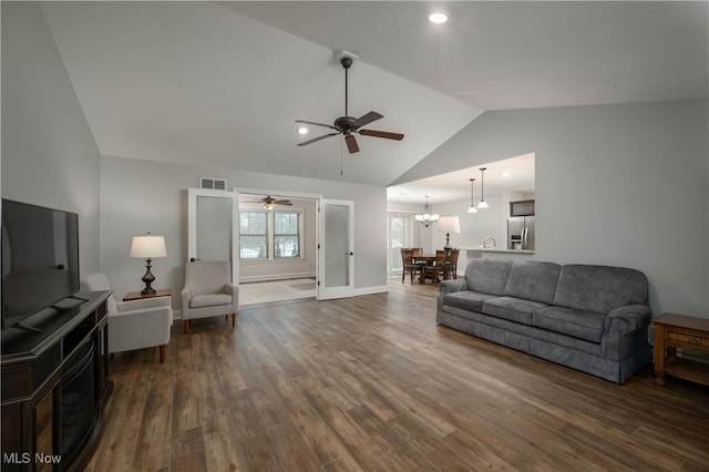 living room featuring dark hardwood / wood-style flooring, french doors, vaulted ceiling, and ceiling fan with notable chandelier