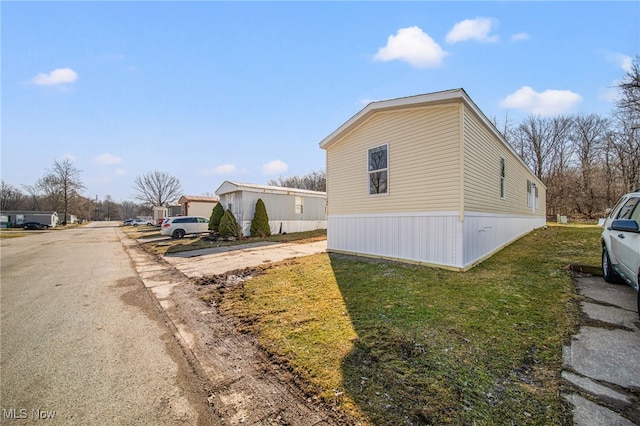 view of property exterior with a yard and driveway