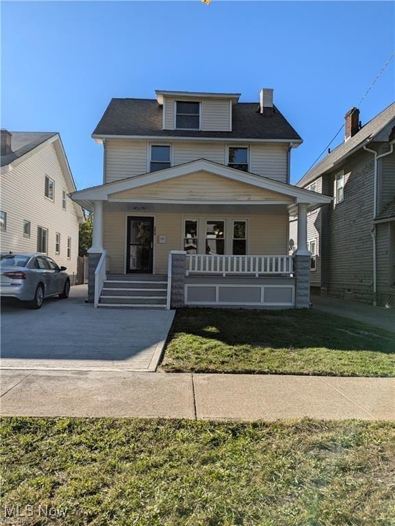 view of front facade with a front yard and covered porch