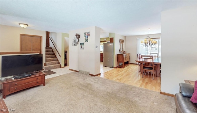 carpeted living room with a chandelier