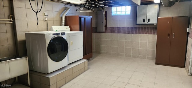 clothes washing area featuring sink, washer and clothes dryer, and electric panel