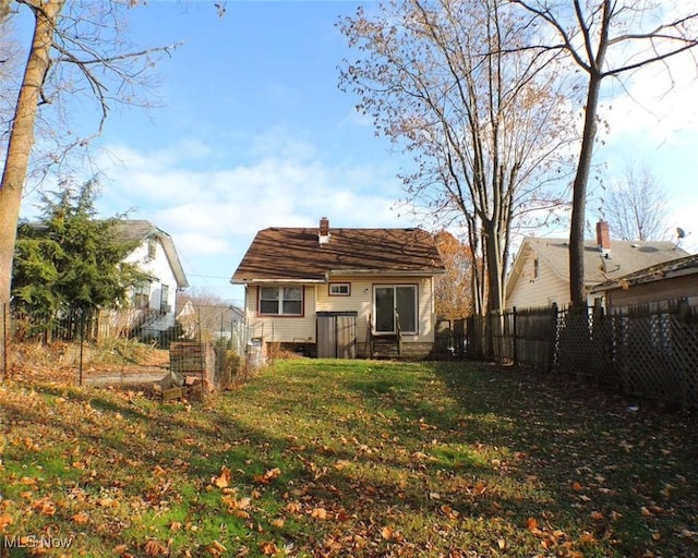 rear view of house featuring a lawn