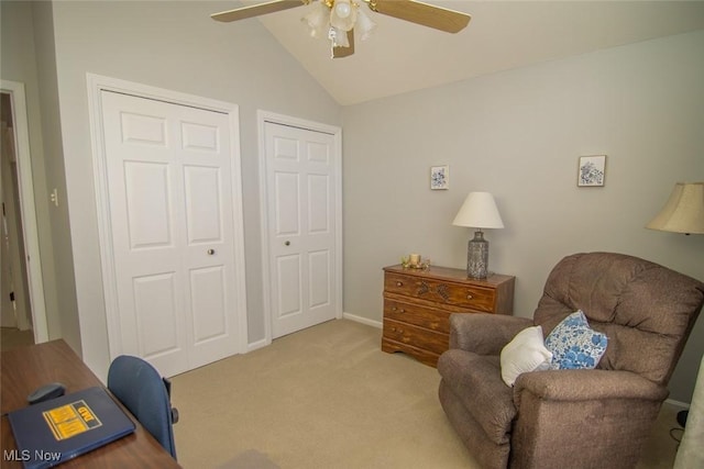 living area featuring vaulted ceiling, ceiling fan, and light carpet