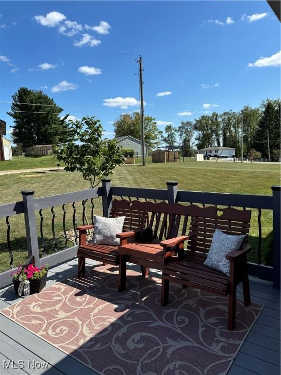 view of property's community featuring a lawn and a deck